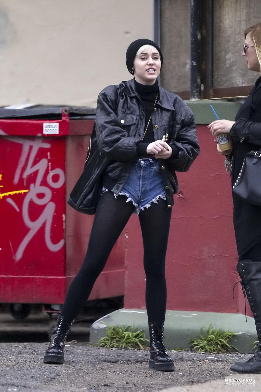 Miley cyrus luce sus piernas y su culo con unos shorts vaqueros y unas medias negras
 #75201687