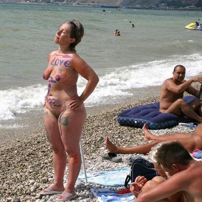 Joven con curvas lo desnuda todo en una playa nudista bajo el sol
 #72255661