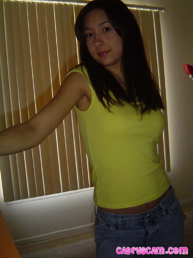 Jeune asiatique aux gros seins montrant son soutien-gorge jaune
 #70008312