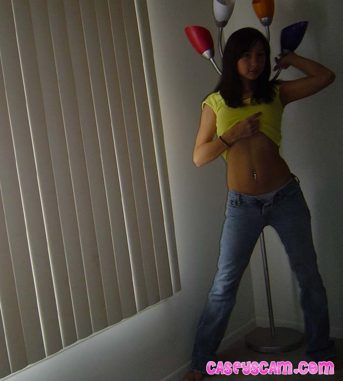 Una joven asiática tetona mostrando su sujetador amarillo
 #70008375