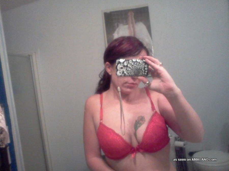 Une nana tatouée s'auto-fixe devant le miroir.
 #67643547