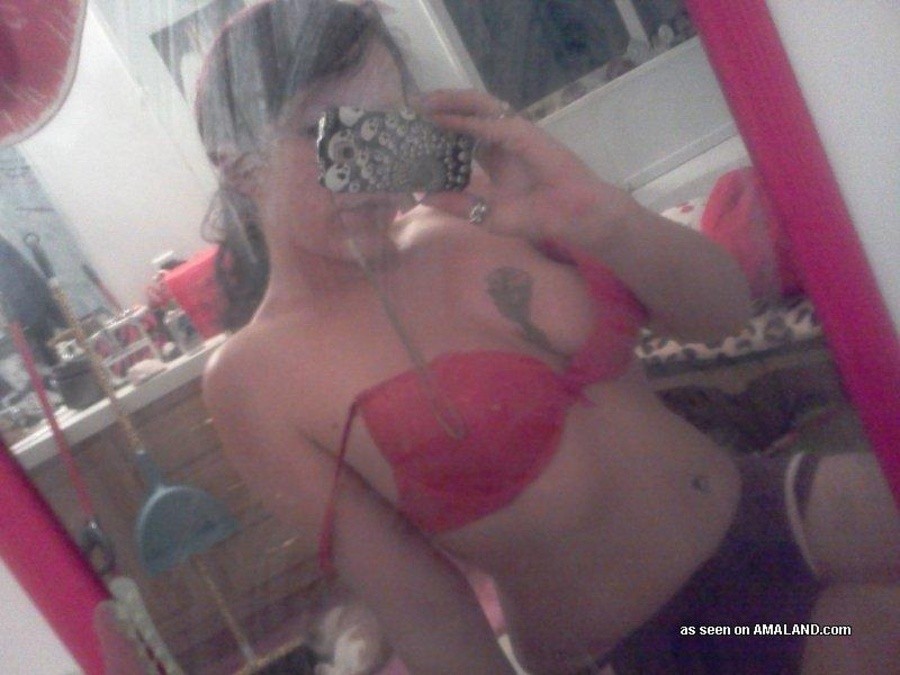 Une nana tatouée s'auto-fixe devant le miroir.
 #67643596