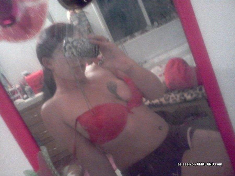 Une nana tatouée s'auto-fixe devant le miroir.
 #67643609