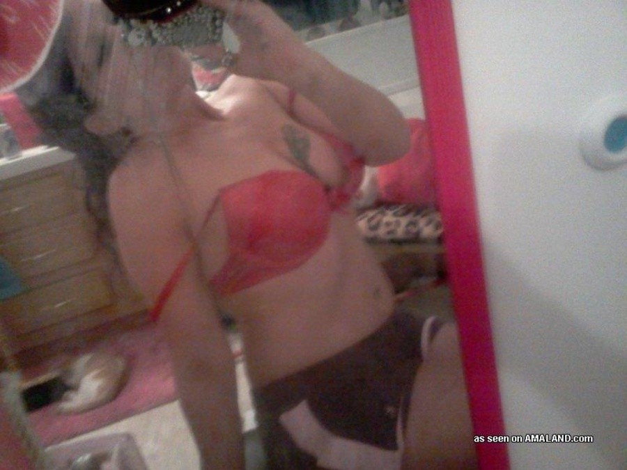 Une nana tatouée s'auto-fixe devant le miroir.
 #67643611