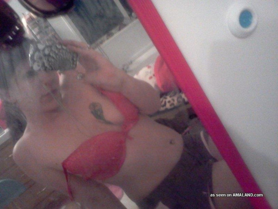 Une nana tatouée s'auto-fixe devant le miroir.
 #67643625