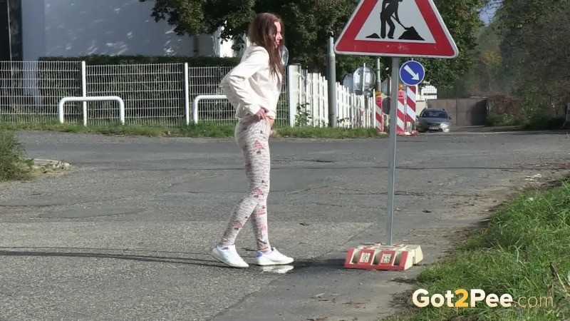 Brunette girl makes a pissy puddle on the road #67480672