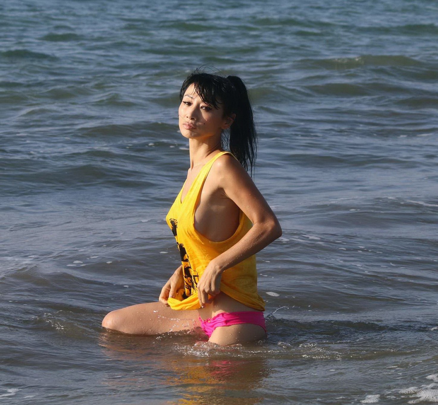 Bai Ling shows sideboob and pokies in wet tshirt and bikini bottom at the beach  #75179112