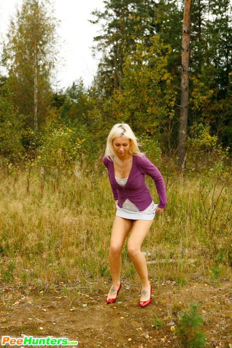 Blonde with tattooed legs pees near forest edge #78692871