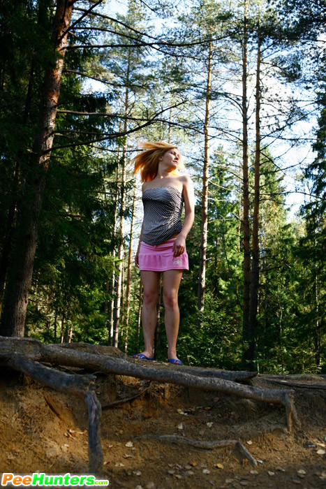 Muñeca joven lujuriosa se desnuda y orina en un tranquilo claro del bosque
 #78690760