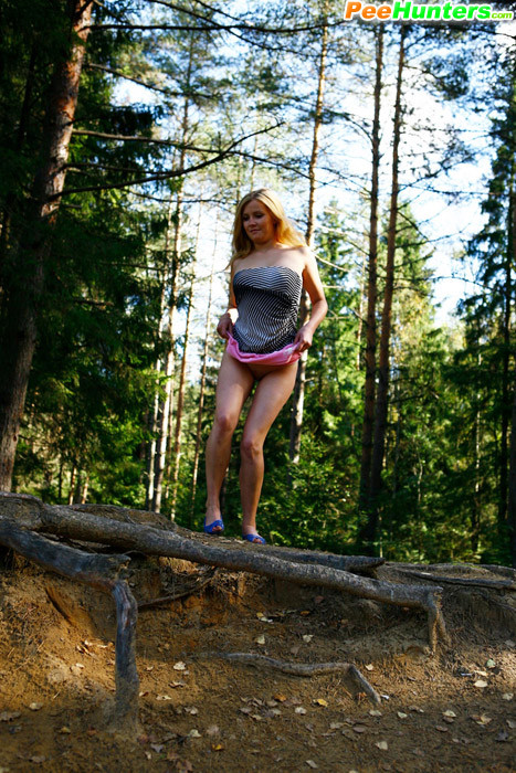 Muñeca joven lujuriosa se desnuda y orina en un tranquilo claro del bosque
 #78690766