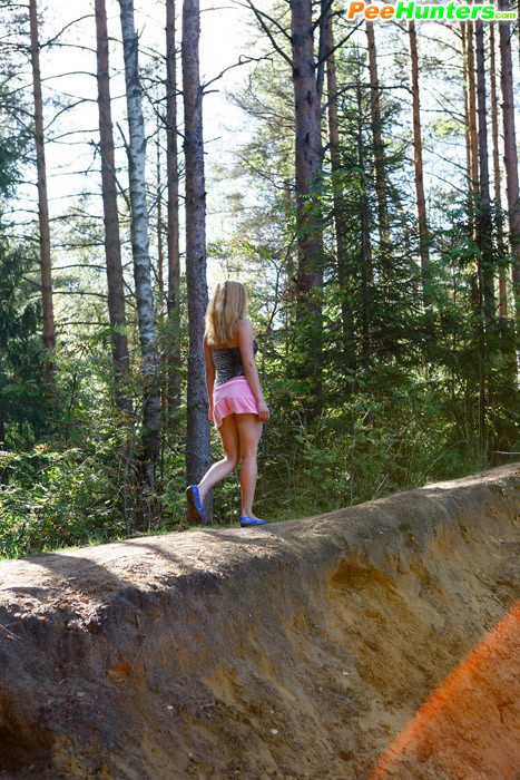 Muñeca joven lujuriosa se desnuda y orina en un tranquilo claro del bosque
 #78690871