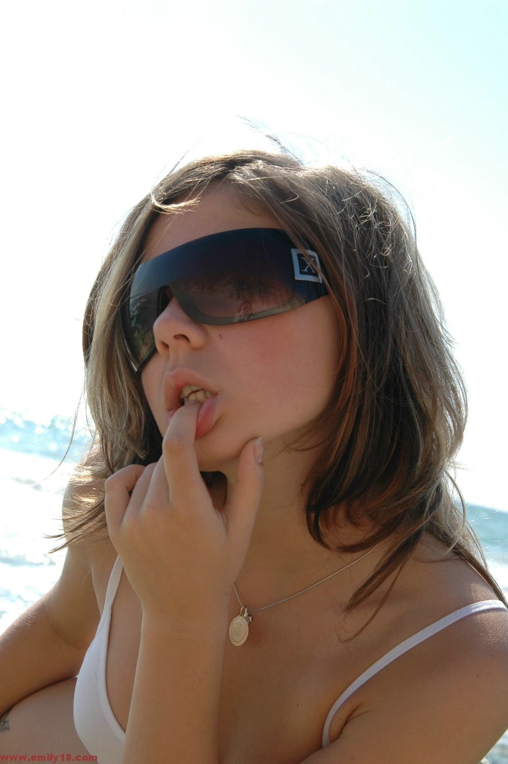 Ragazza giovane amatoriale in bikini e occhiali da sole in spiaggia
 #72311642
