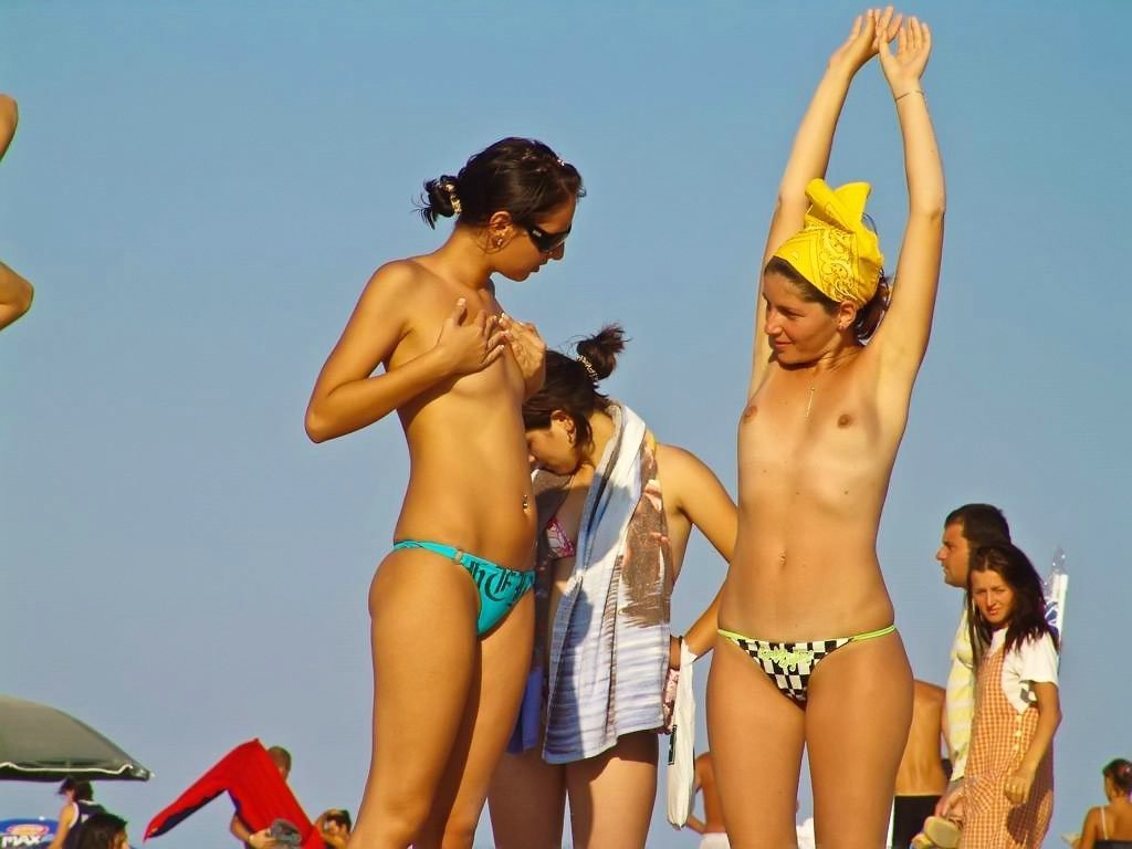 Nackte Teenie-Mädchen spielen zusammen an einem öffentlichen Strand
 #70058178