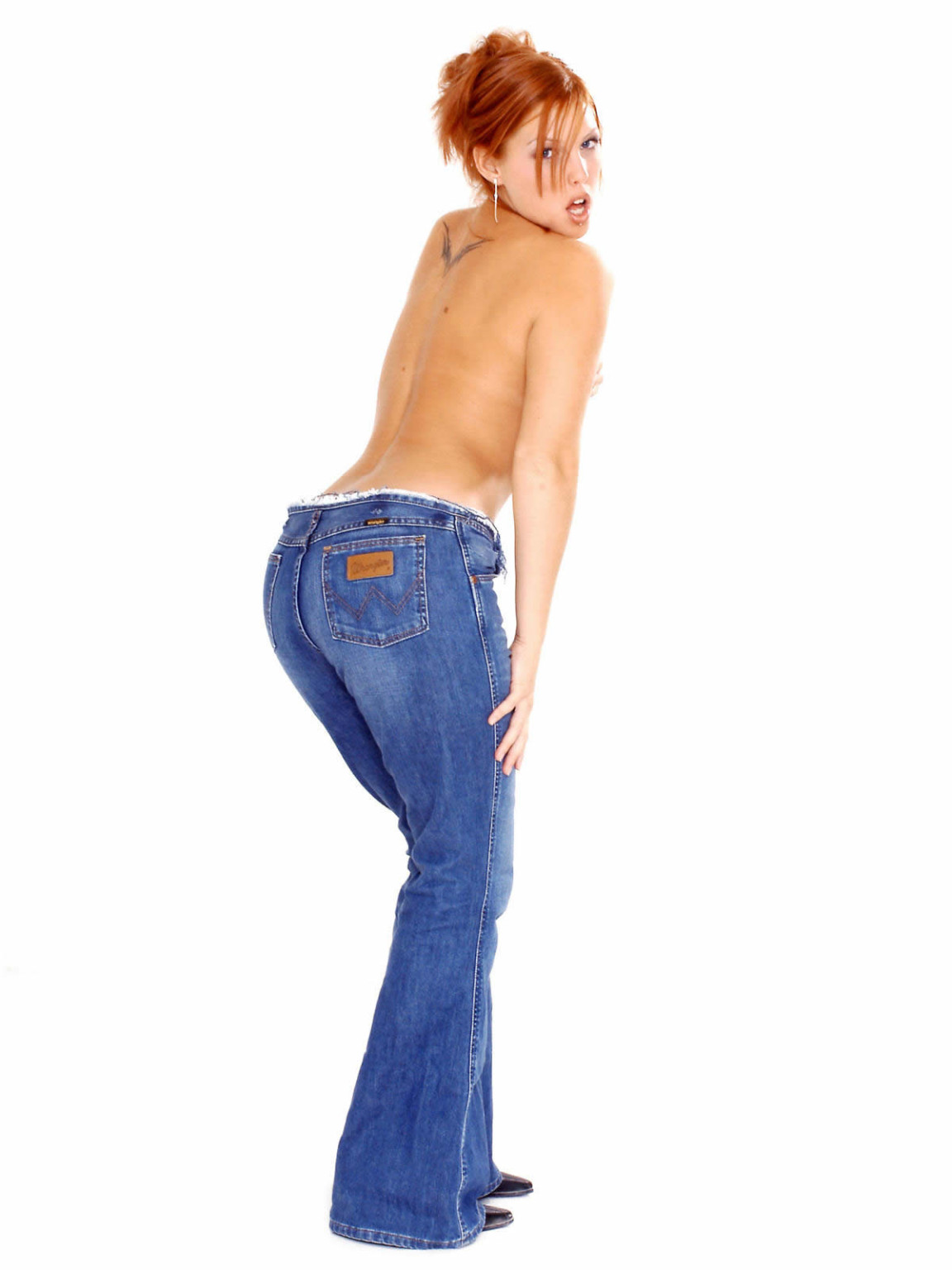 Une jeune rousse fait glisser son jean et sa culotte.
 #70667861