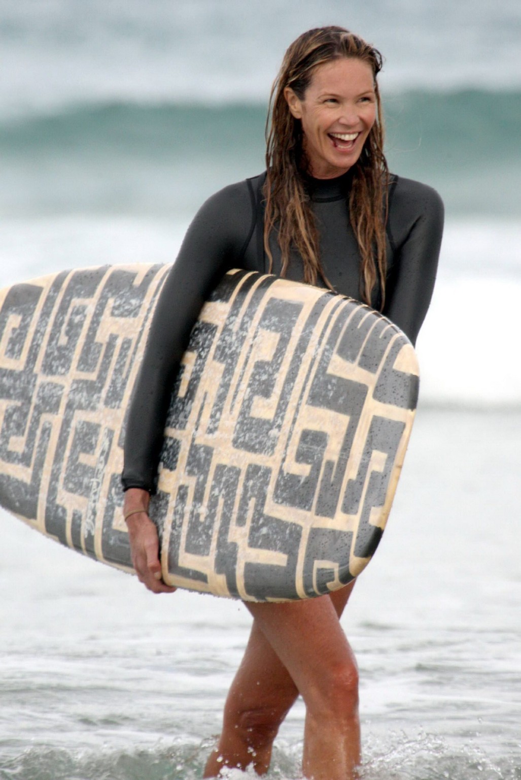 Elle MacPherson surfing in black suit on a beach in Sydney, Australia #75277620