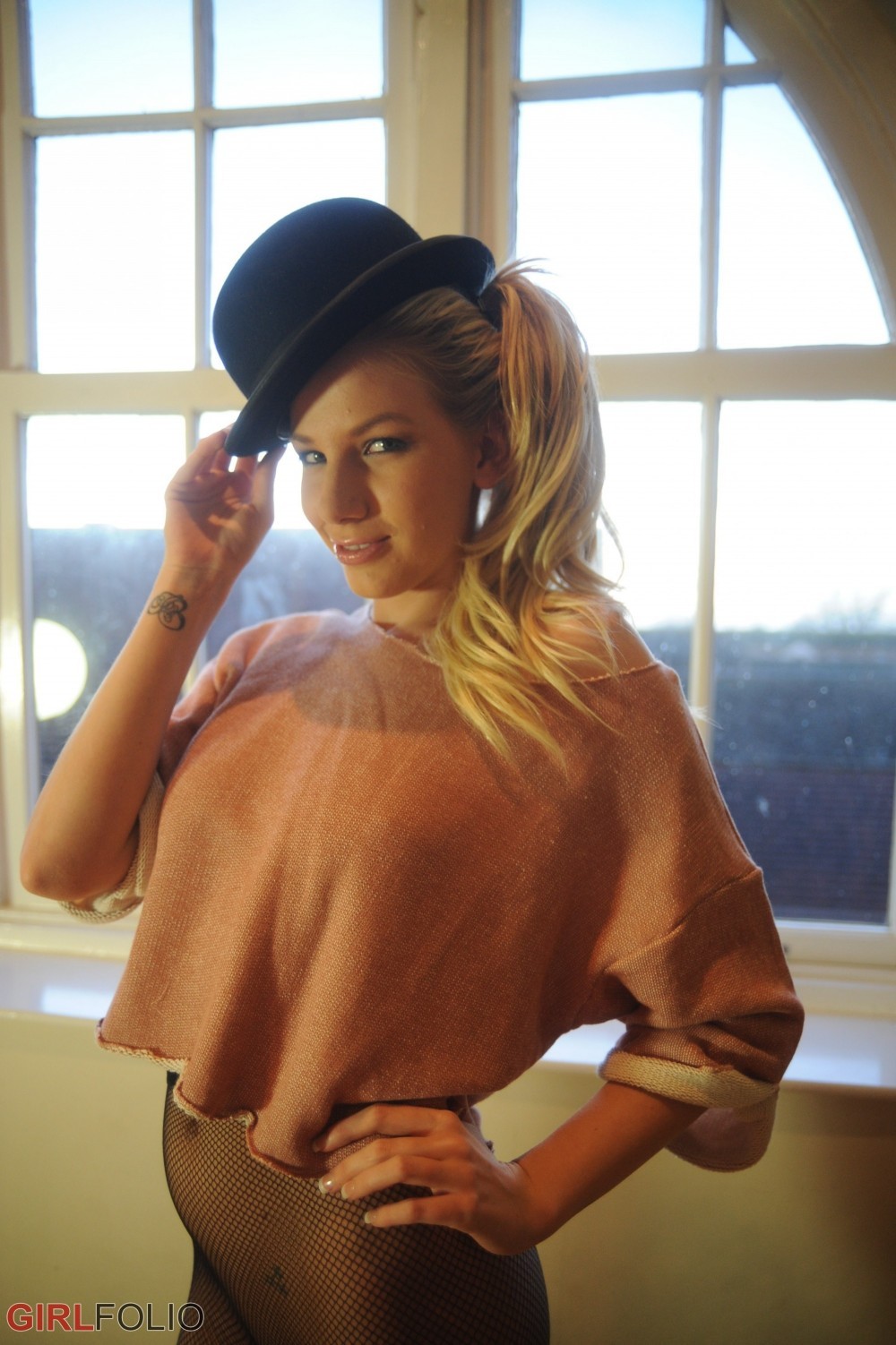 Sexy Blondine in ihrem schwarzen Hut und Netzstrumpfhosen
 #72500447