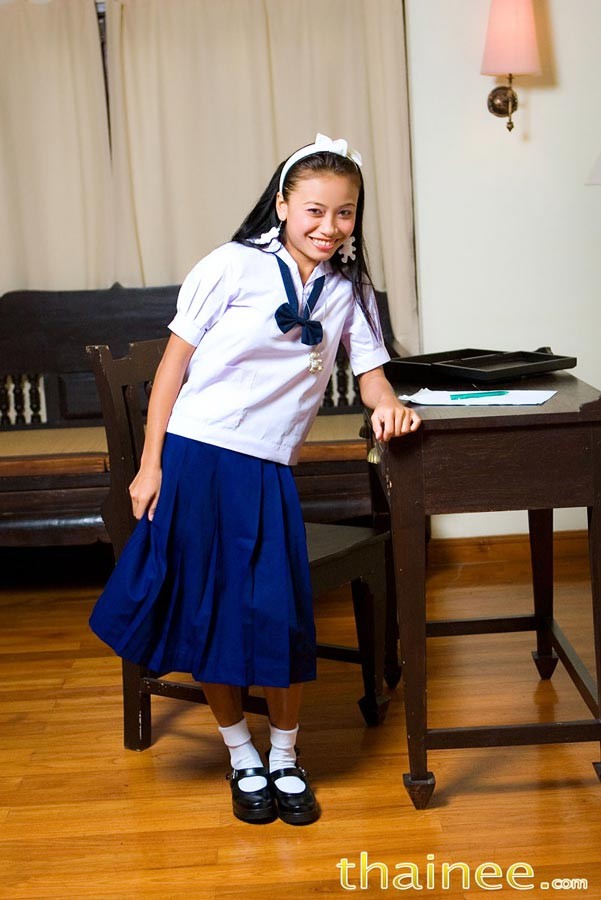 Thai teen girl in schoolgirl uniform strips