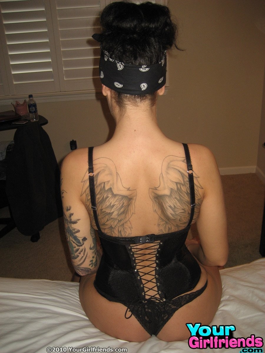 Freundin bedeckt in Tattoos in einem Korsett wird nackt in ihrem Schlafzimmer.
 #67331197