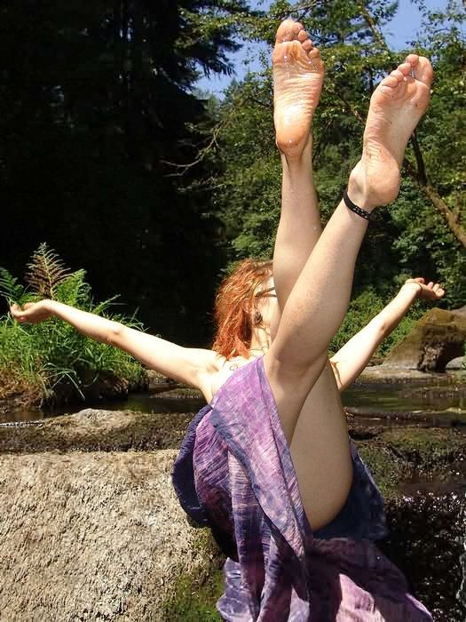 Une nudiste aux pieds nus et poilus qui balance ses orteils dans un ruisseau
 #76622474