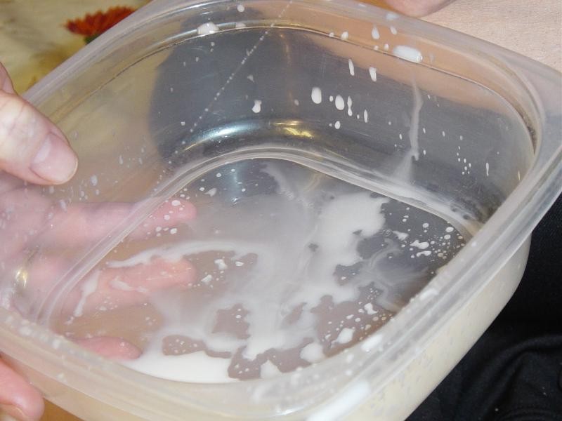 Mutter laktiert frische Milch von ihren schönen Titten in einem Behälter
 #76578631