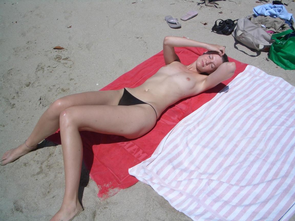 Une fille nue aux seins volumineux pose sur une plage nue
 #72250022