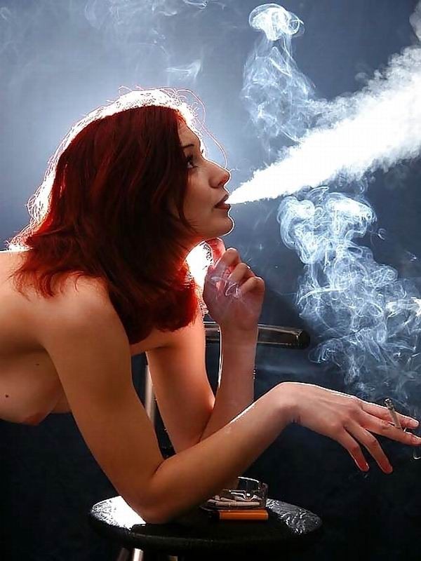 Chica pelirroja fuma un cigarrillo mientras posa
 #67861251