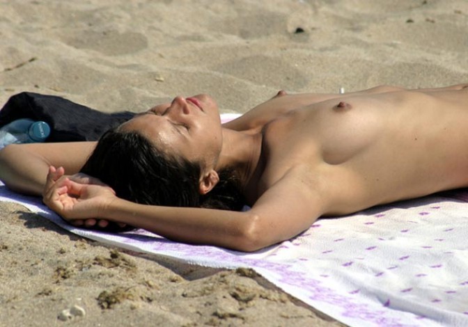 Una rubia nudista se desnuda en una playa pública
 #72248256