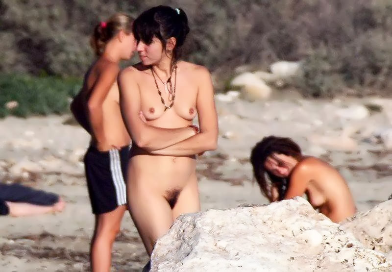 Jeunes nus jouant ensemble sur une plage publique
 #67092134