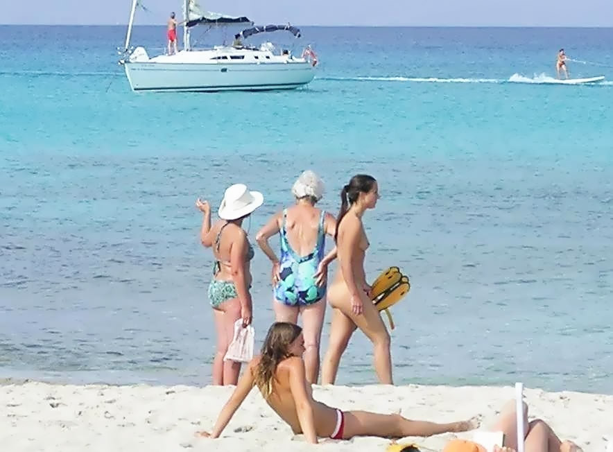 Jeunes nus jouant ensemble sur une plage publique
 #67092143