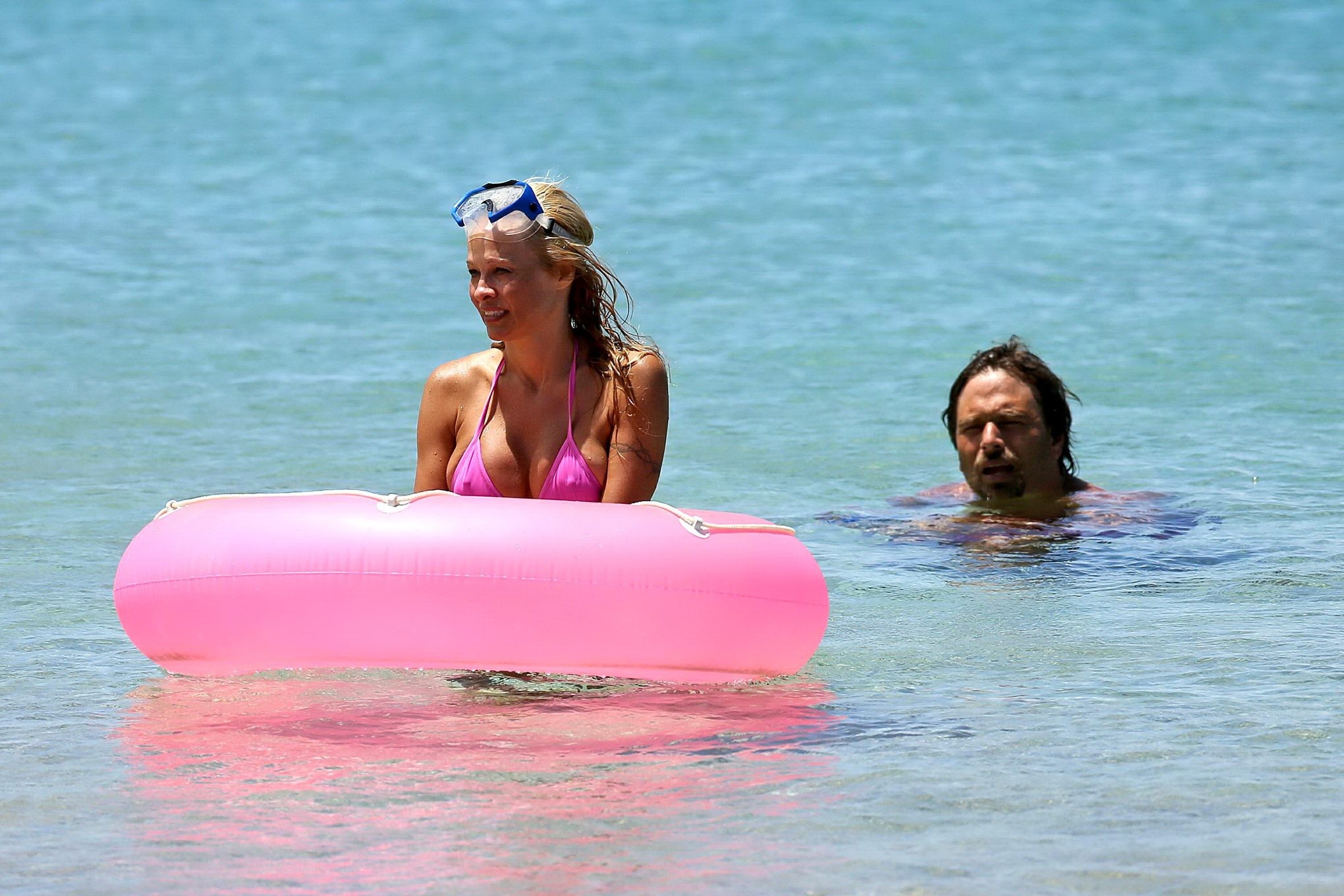 Busty pamela anderson mostrando pokies in un bikini rosa bagnato mentre lo snorkeling su un 
 #75221497