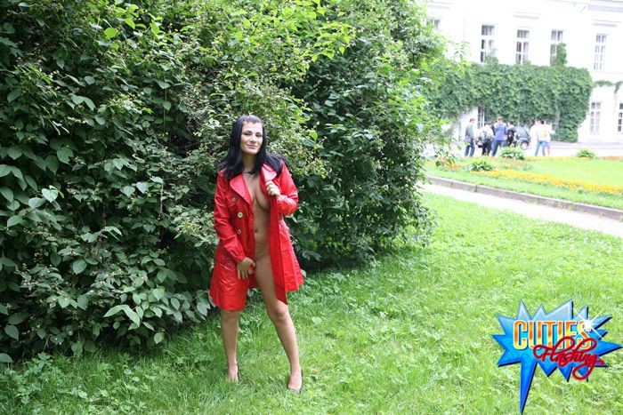 Morena sexual en abrigo de cuero rojo exhibiéndose en el parque
 #72615927
