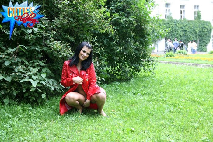Sexuelles brünettes Mädchen in rotem Ledermantel blinkt im Park
 #72615931