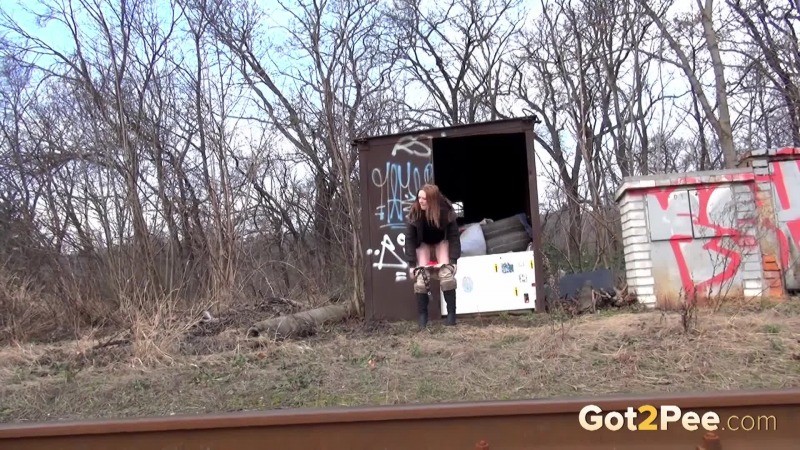 Brunette girl pulls down her trousers to pee outside #67493290