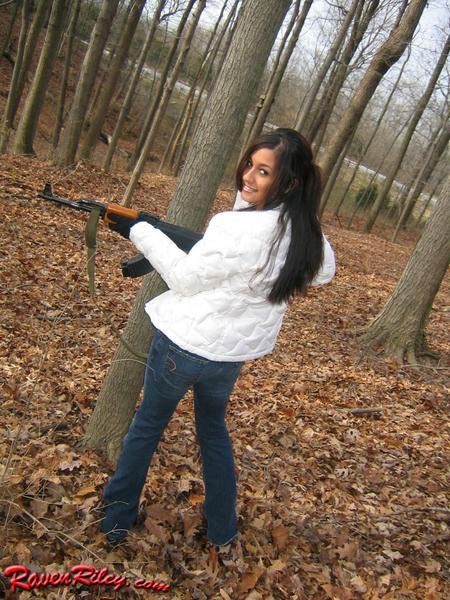 Nena posando con una pistola en el bosque
 #75101334