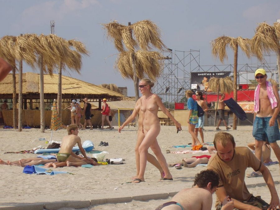 Une jeune nudiste montre son corps mince à la plage.
 #72256703