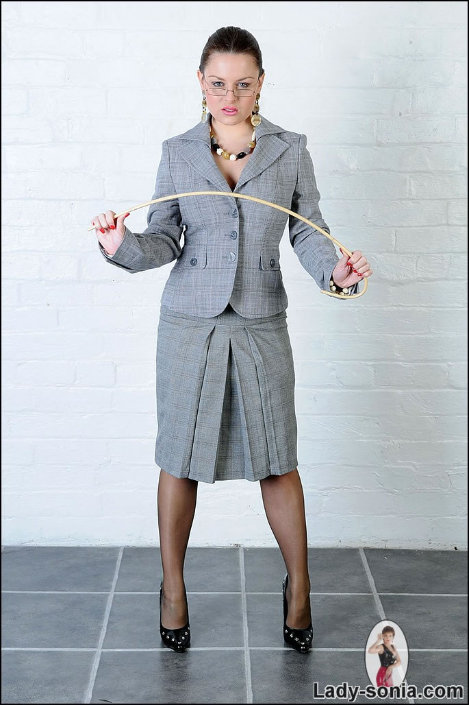 Business suited british dominatrix poses with cane #76484740