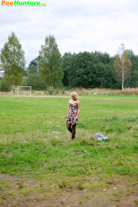 Blonde girl takes a leak in the middle of a field #78690355