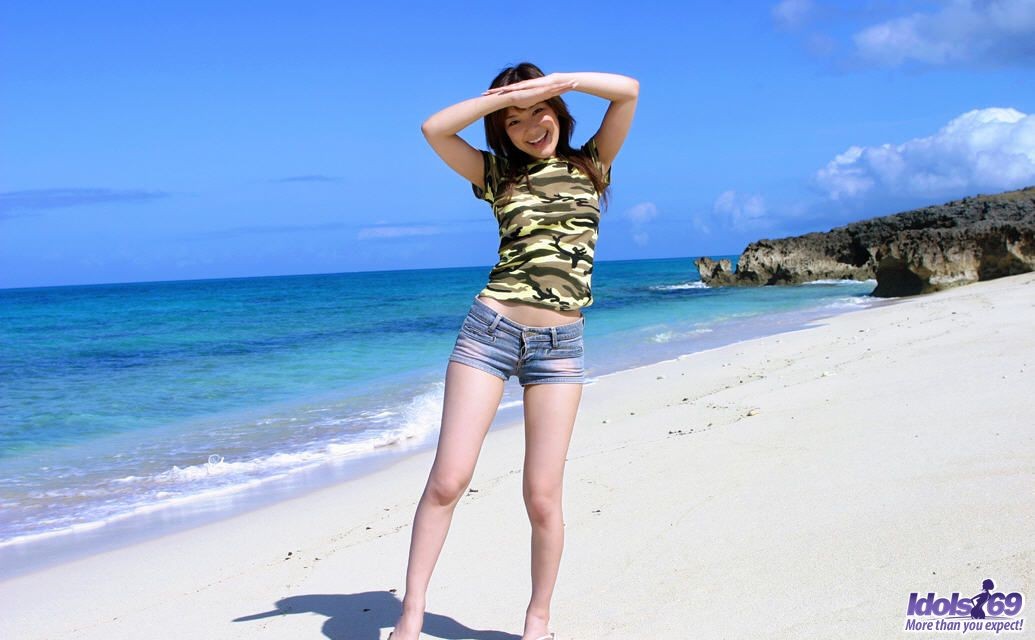 Petite ragazza giapponese con piccoli pantaloncini si spoglia nuda sulla spiaggia
 #69973806