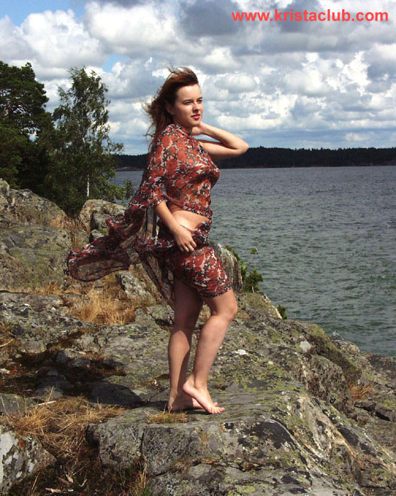 Sexy redhead girl posing on cliffs near water #76647433