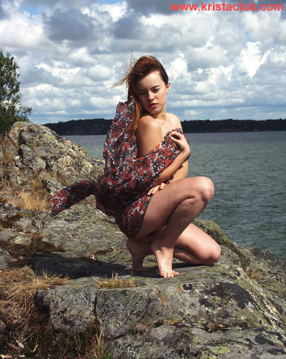 Fille rousse sexy posant sur des falaises près de l'eau
 #76647444