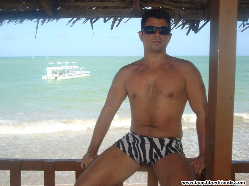 Sexy ragazzo corposo è in topless in spiaggia in posa i loro addominali
 #76945361