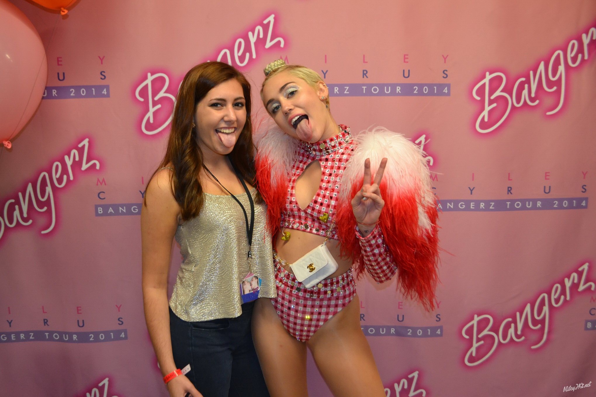 Miley Cyrus leckt einen Fan ab, während sie für ein Meet-and-Greet-Event im United Center posiert
 #75188106