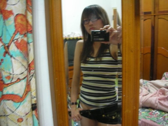 Chica china con gafas posando para autofotos
 #69964816