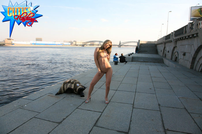 Une jeune exhibitionniste montre son corps sur la berge d'une rivière.
 #71565337