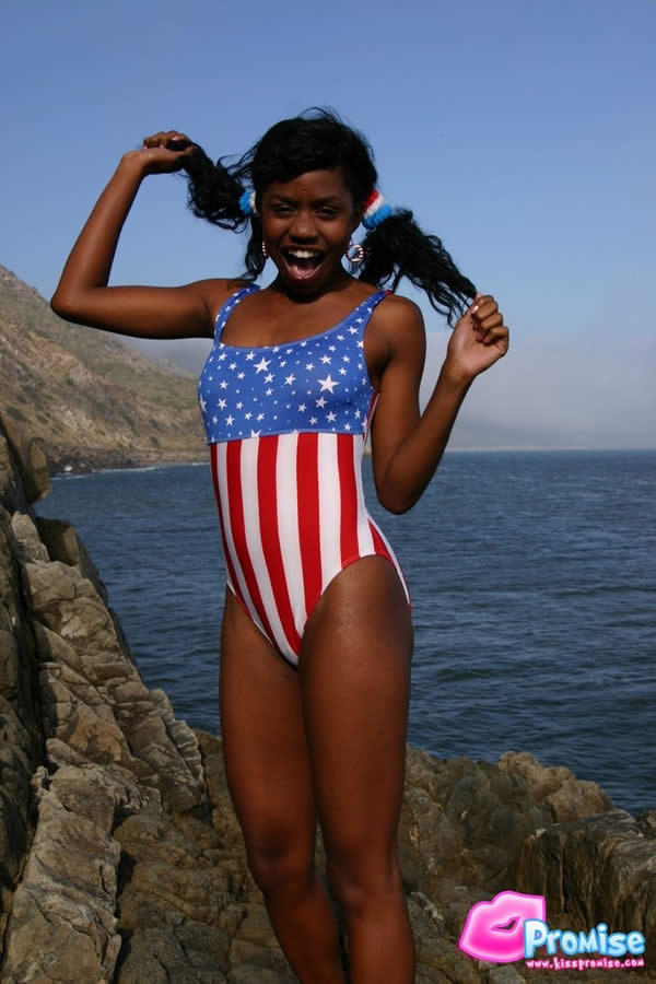 Ebony teen in bathing suit strips by the ocean #73422275