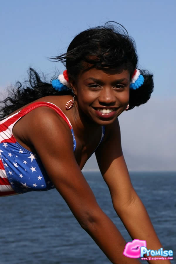 Ebony teen in bathing suit strips by the ocean #73422299