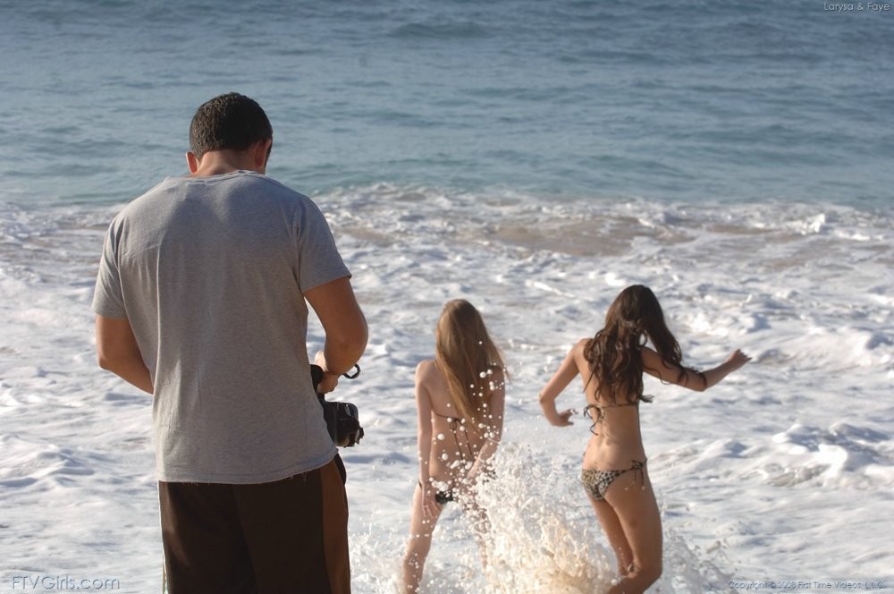 Deux jeunes filles en bikini sexy exhibant leurs seins sur une plage de sable.
 #72315545
