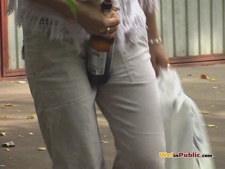 金髪の女性がビールを飲みながら白いズボンに小便をする
 #73255536