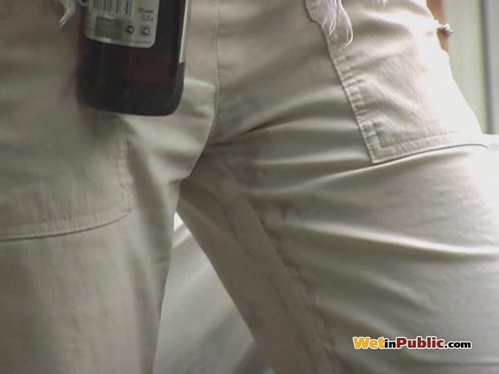 金髪の女性がビールを飲みながら白いズボンに小便をする
 #73255553
