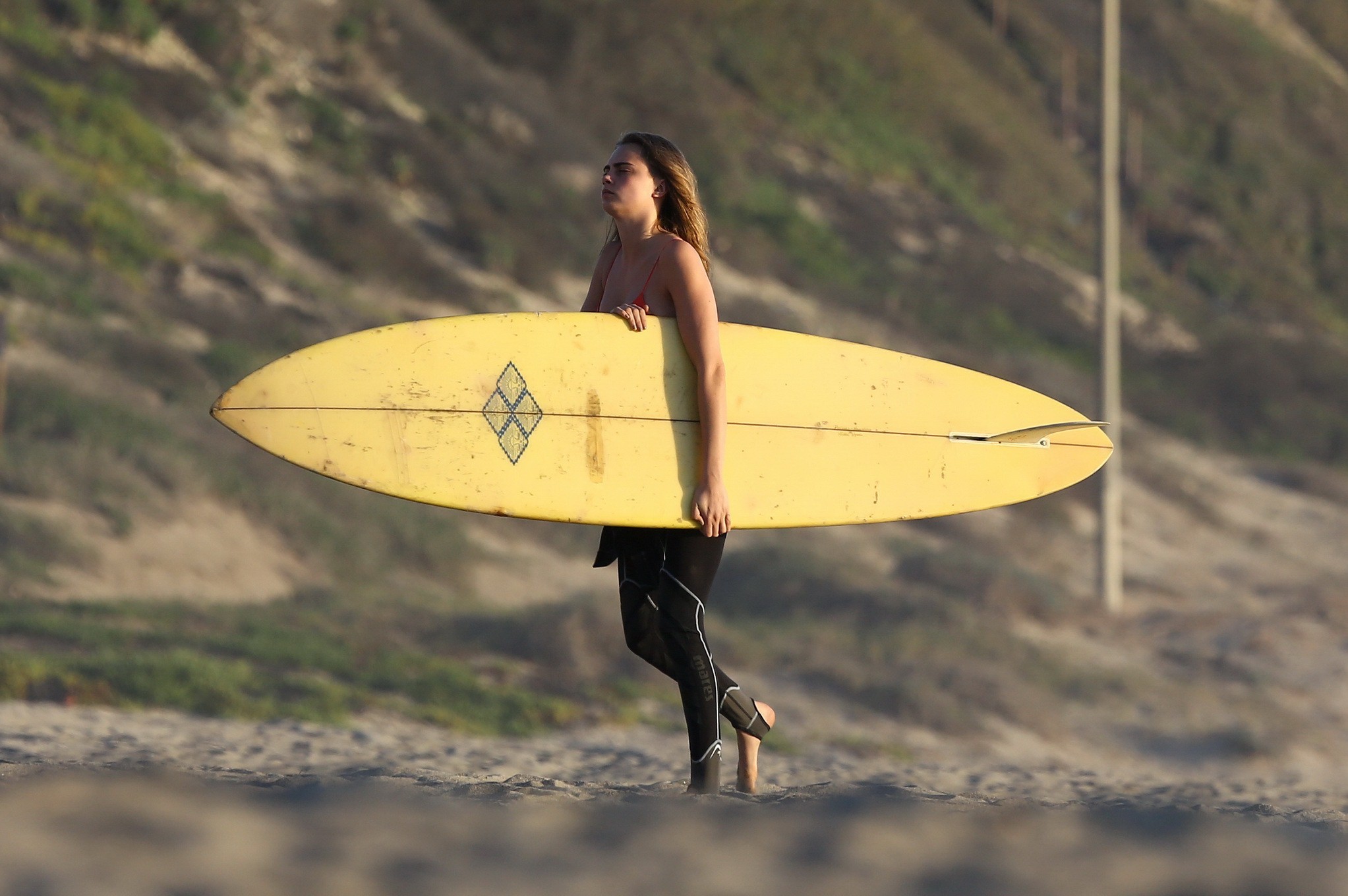 Cara Delevingne wearing red bikini top and black wetsuit while filming Paper Tow #75175688